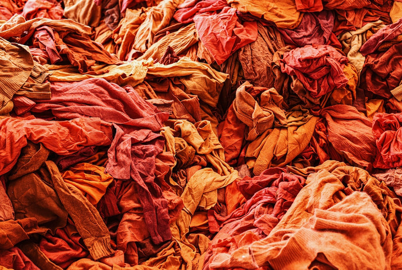 A pile of orange cashmere sweaters waiting to be shredded for recycling